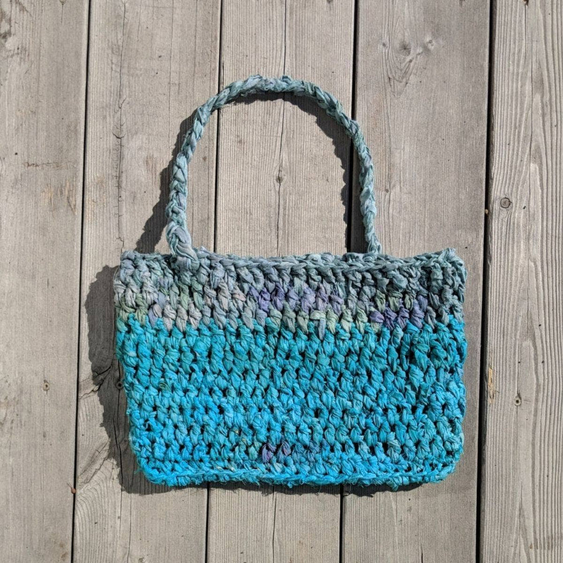 Sea Waves Beach Bag crochet pattern featuring teal, blue, and grey textured silk yarn.