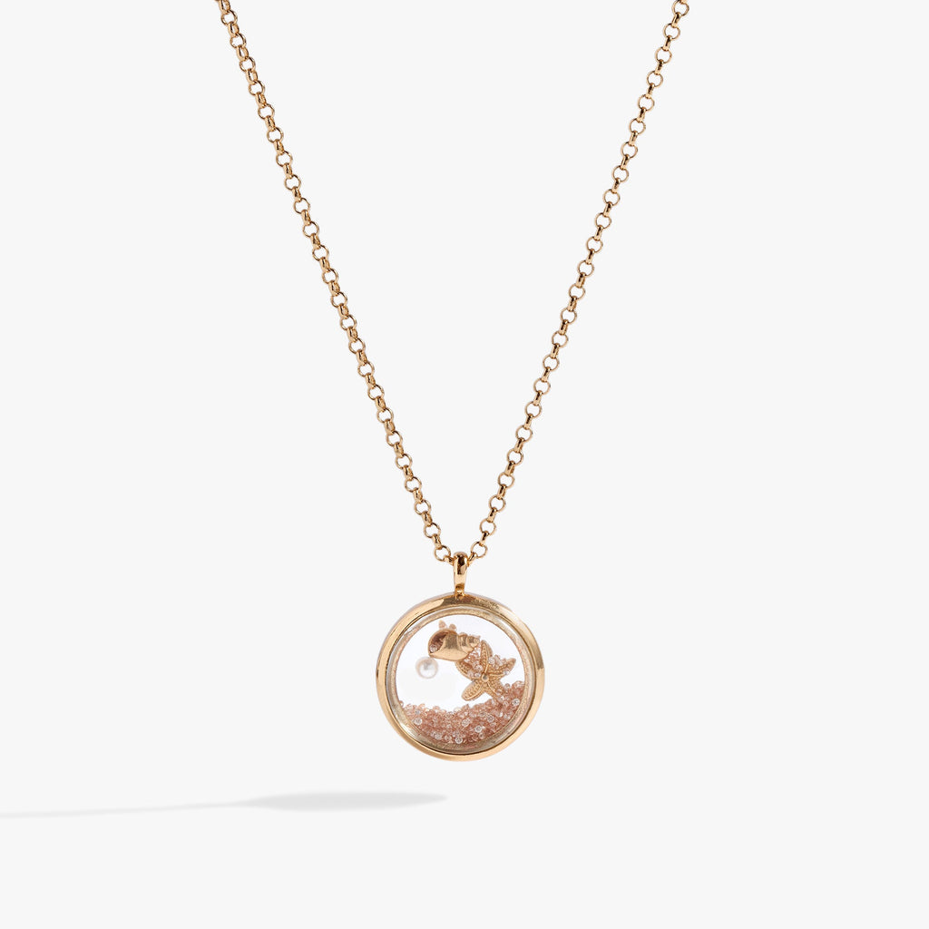 Gold circle pendant necklace filled with sand, pearl, seashell, and starfish charm.