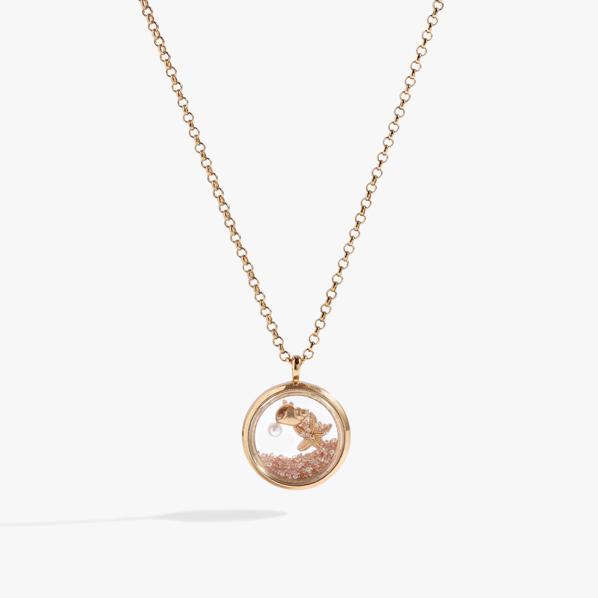 Gold circle pendant necklace filled with sand, pearl, seashell, and starfish charm.