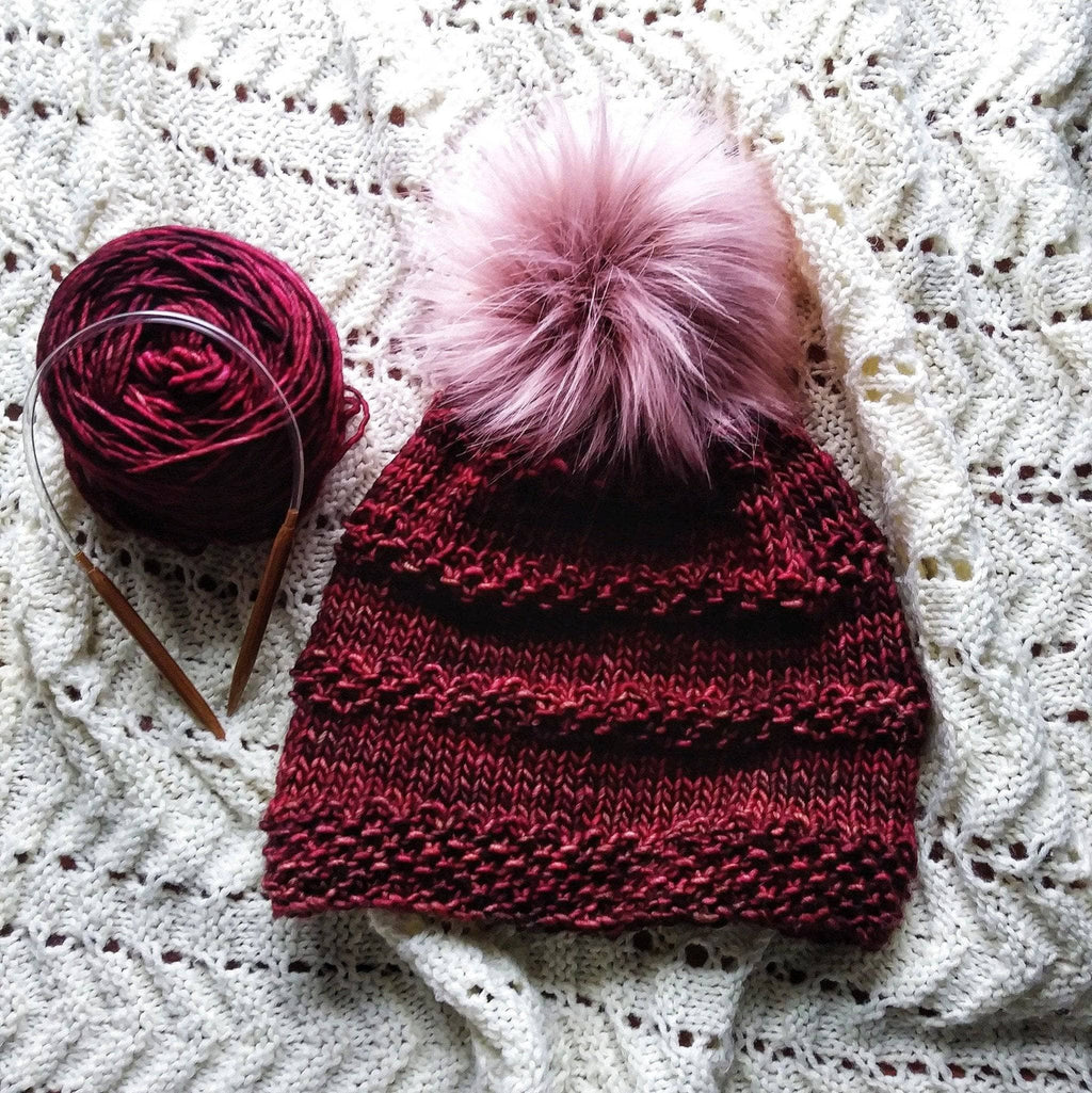 A soft, textured hand-knitted Seed Ridge Beanie displayed in a cozy winter setting.