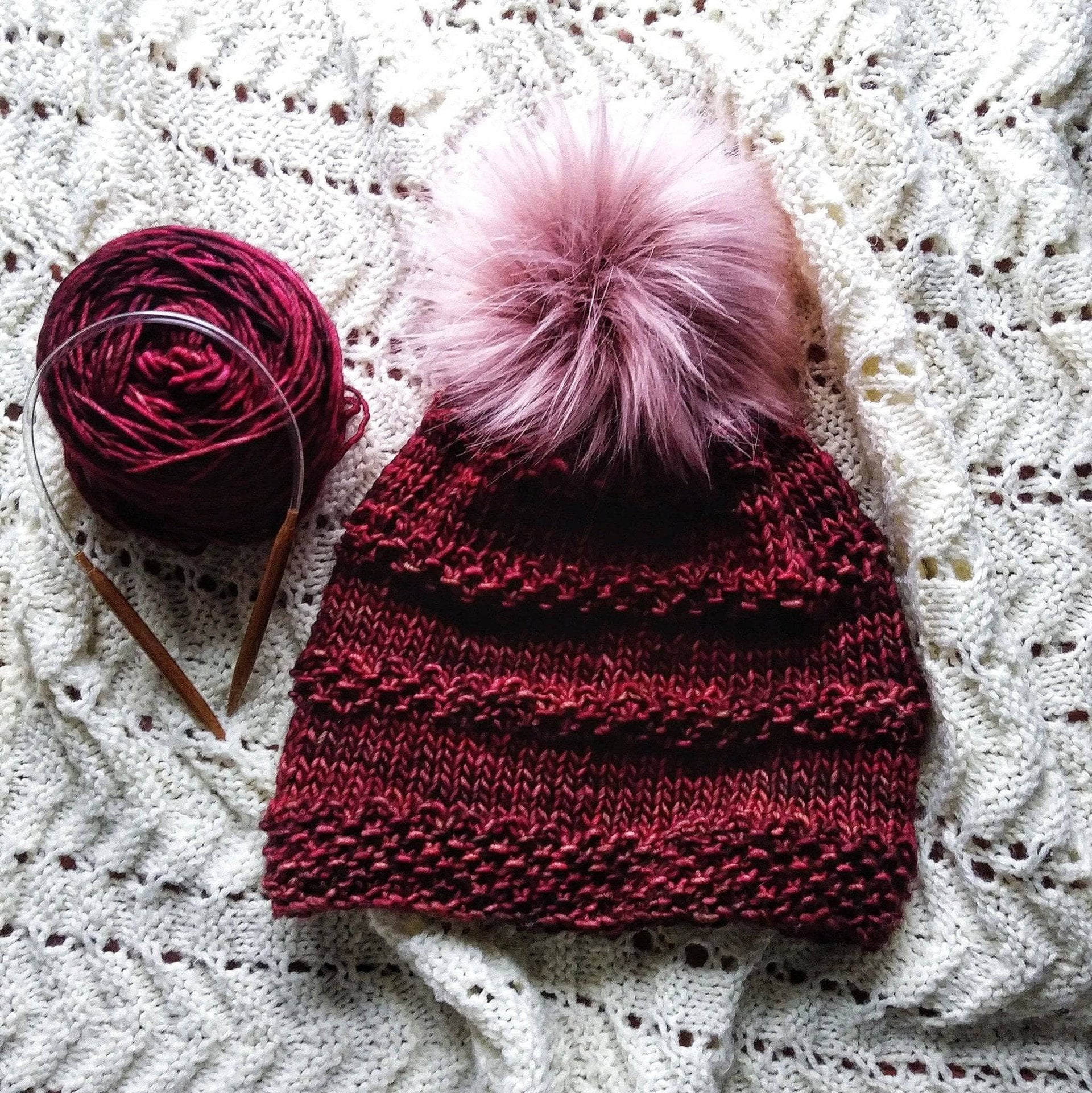 A soft, textured hand-knitted Seed Ridge Beanie displayed in a cozy winter setting.