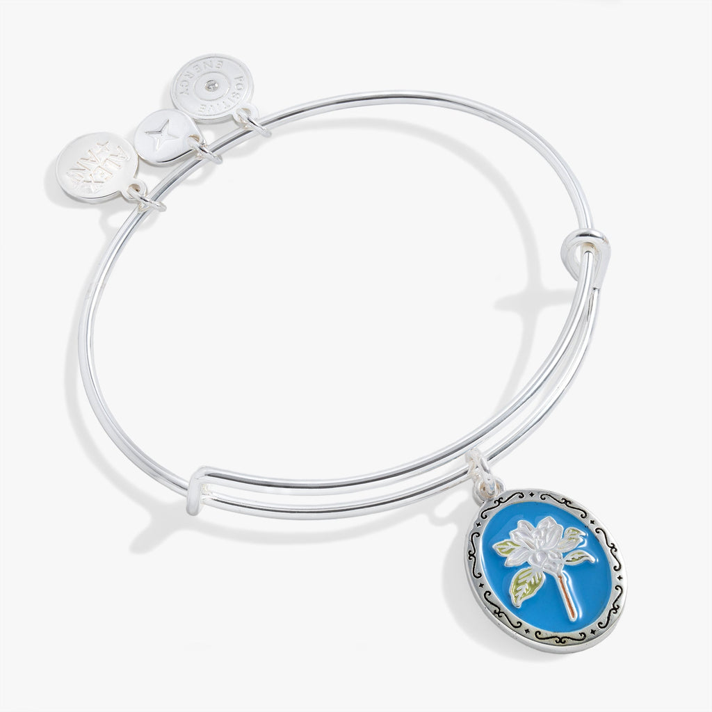 Bangle bracelet with a framed flower charm on a blue background, engraved with 'Sending Love' on the back.