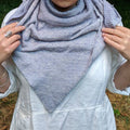 Close up of a delicate knitted lace weight silk shawl showcasing intricate stitch detail