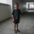 Child wearing a charcoal grey cotton blend short set with an abstract print.