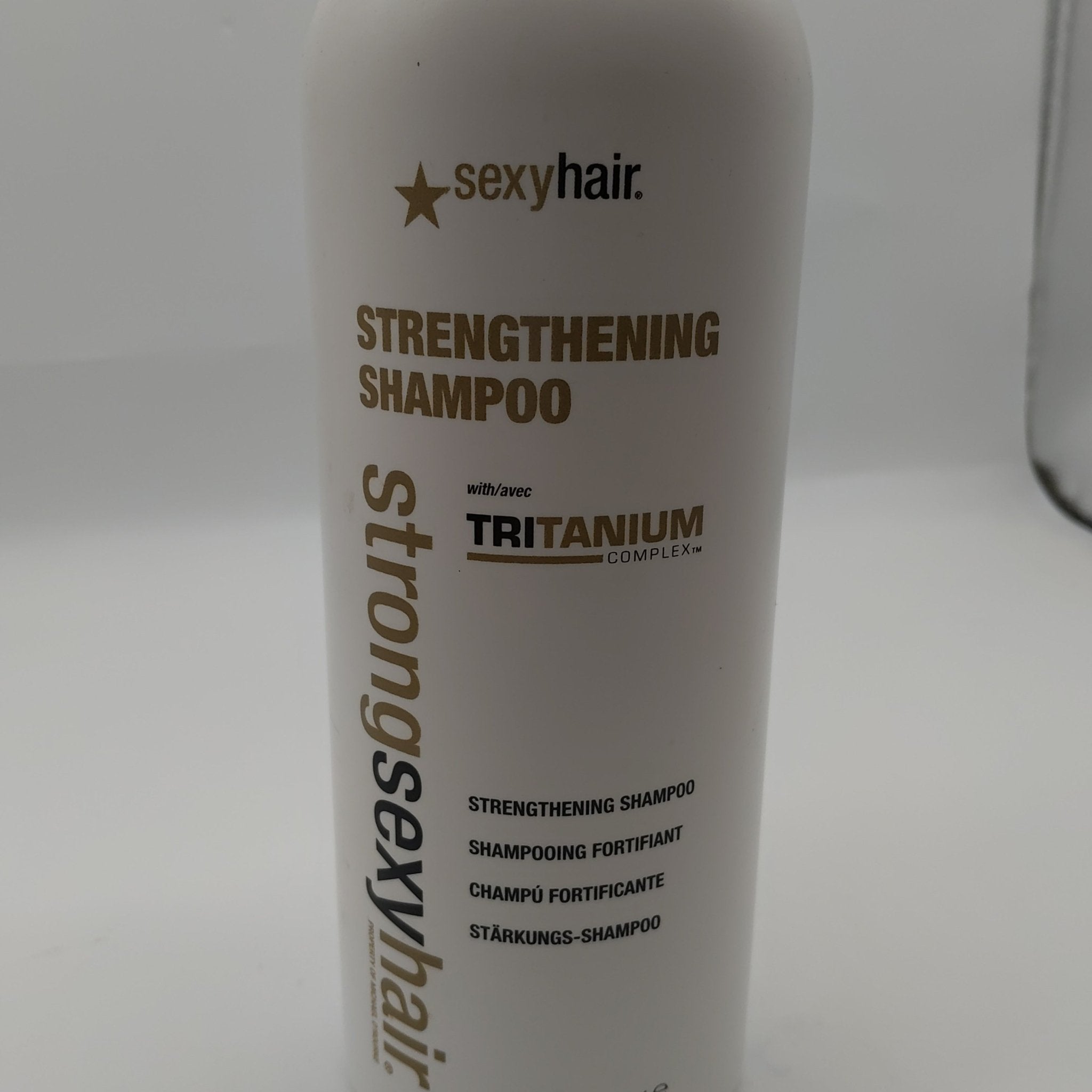 White bottle of Sexy Hair Strengthening Conditioner with gold and black typography, 33.8 oz size.