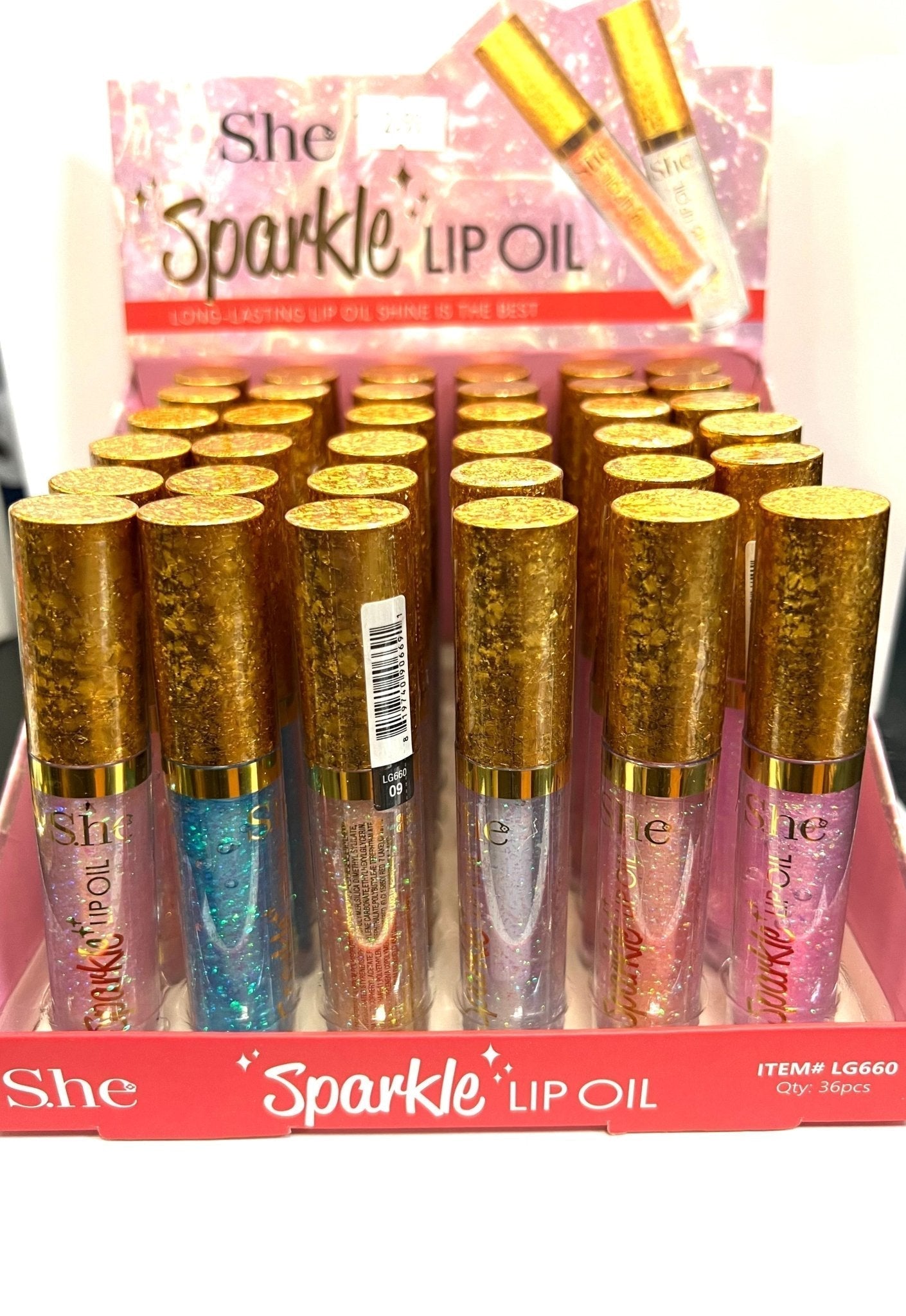 S.HE Sparkle Lip Oil with gold shimmer in a clear bottle