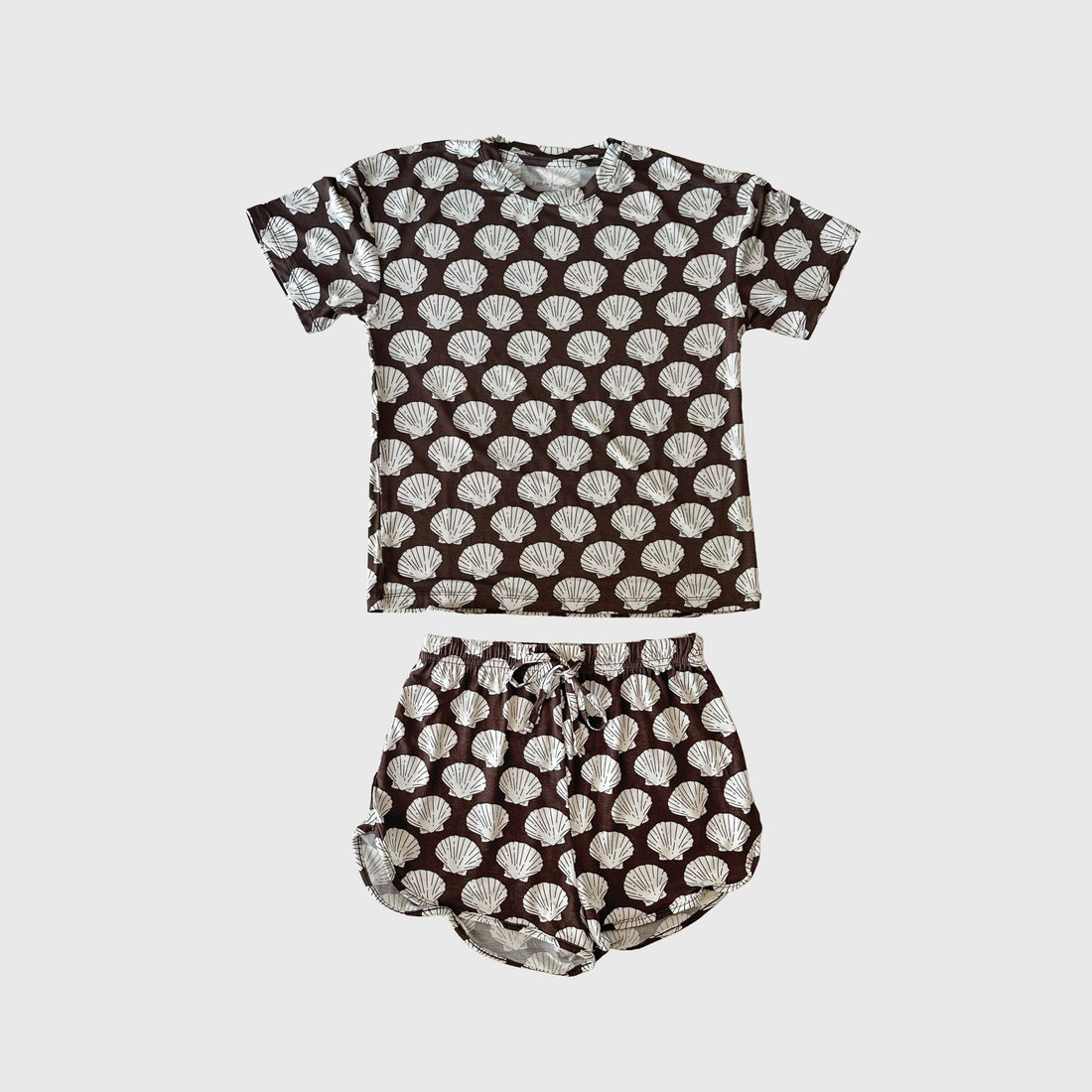 Girl wearing a brown and white seashell print bamboo biker short set.