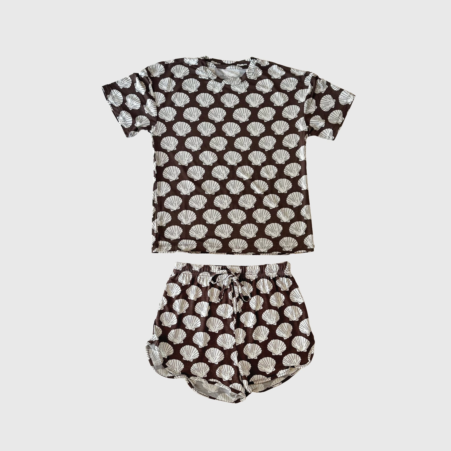 Girl wearing a brown and white seashell print bamboo biker short set.