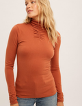 Close up of Sofia Shirring Mock Neck Sweater in rust knit fabric showing neckline detail