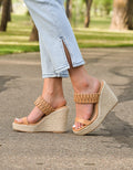 A pair of Atlas Wedge sandals in a natural tan color featuring a minimalist bohemian design.