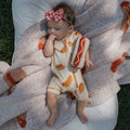 Newborn baby wearing a bamboo shortie zip romper with a hot dog pattern