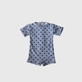 Baby wearing a navy and light blue polka dot shortie swimsuit with short sleeves and snaps.