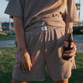 Women wearing a cola brown and white striped terry short set in a casual loungewear style