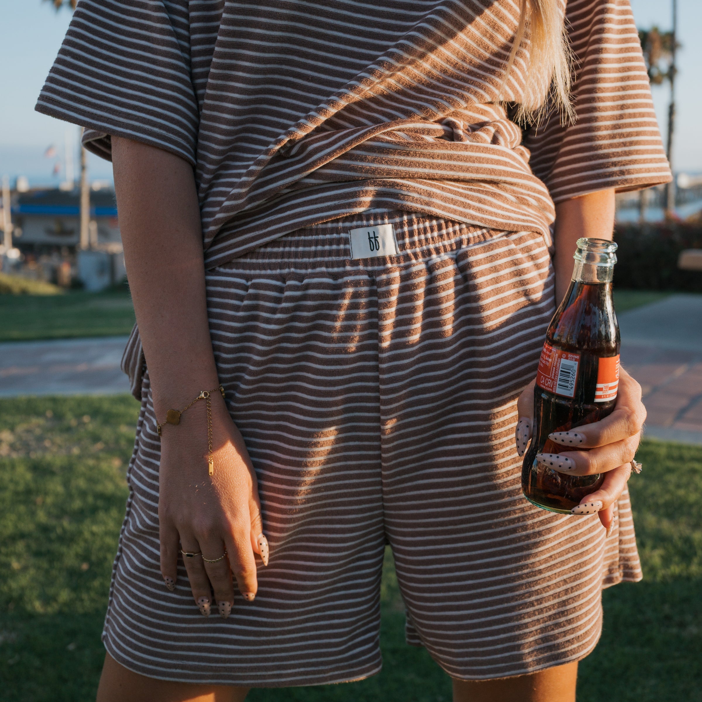 Women wearing a cola brown and white striped terry short set in a casual loungewear style