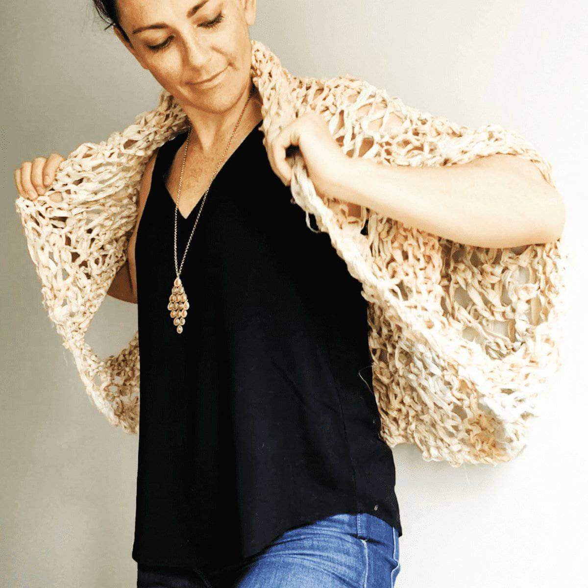 A lightweight, lacy cocoon coat knitted in a shawl-like style, displayed over a simple outfit.