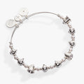 Holiday-themed expandable bangle featuring engraved bell charms and pearl crystal beads.