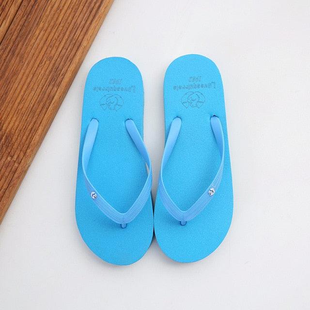 A pair of comfortable women's beach flip flops in solid blue, featuring a soft-touch upper and non-slip rubber sole.