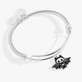 Silver-tone twisted wire bangle featuring a smiling bat skeleton charm with wings spread wide.