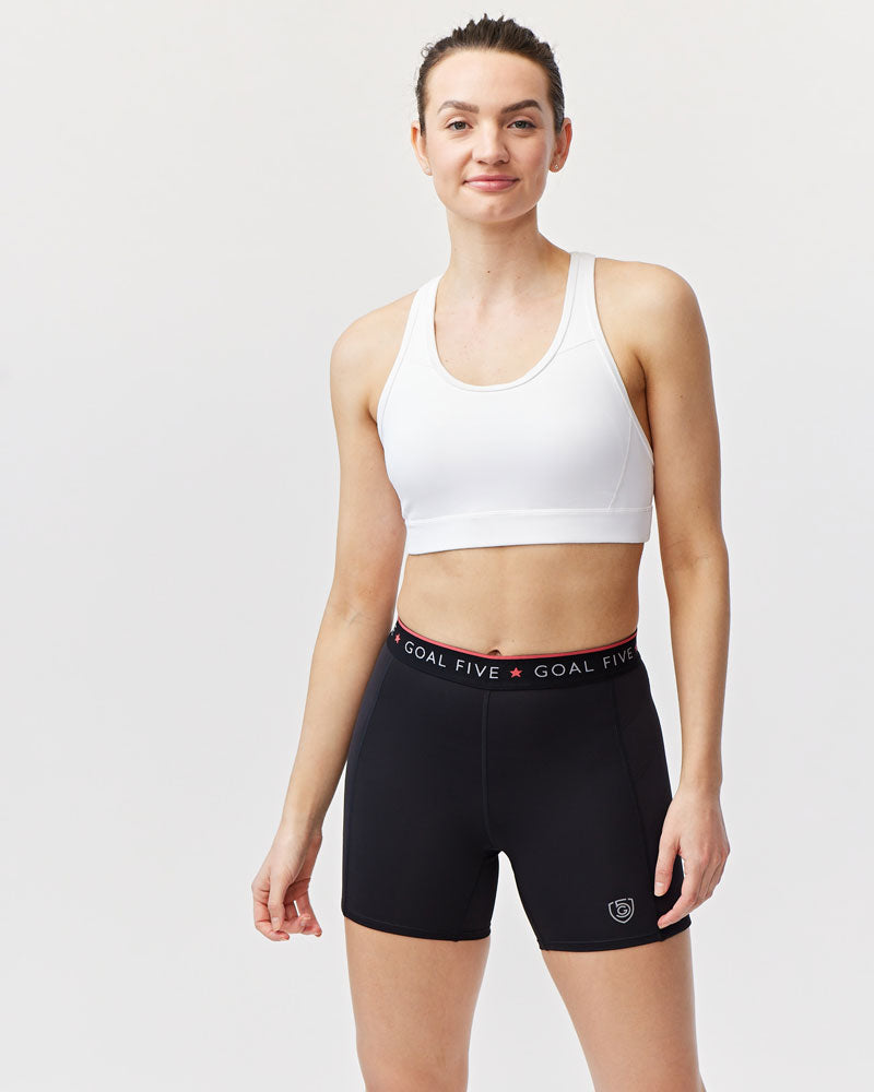 Woman wearing black Goal Five compression slide shorts on the soccer field