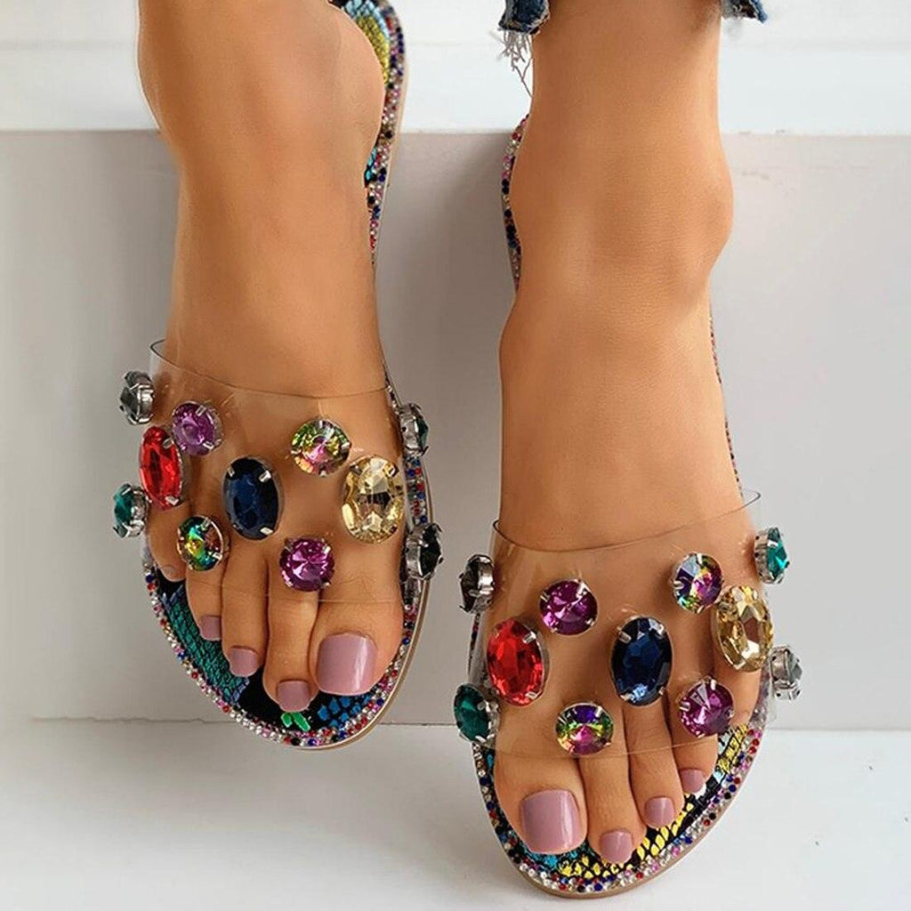 Women's flat slide sandals featuring clear rhinestone embellishments and an open-toe design.