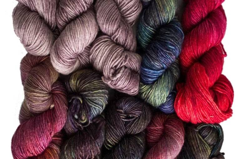 Three skeins of premium hand-dyed yarn bundled together in varying artistic colorways.