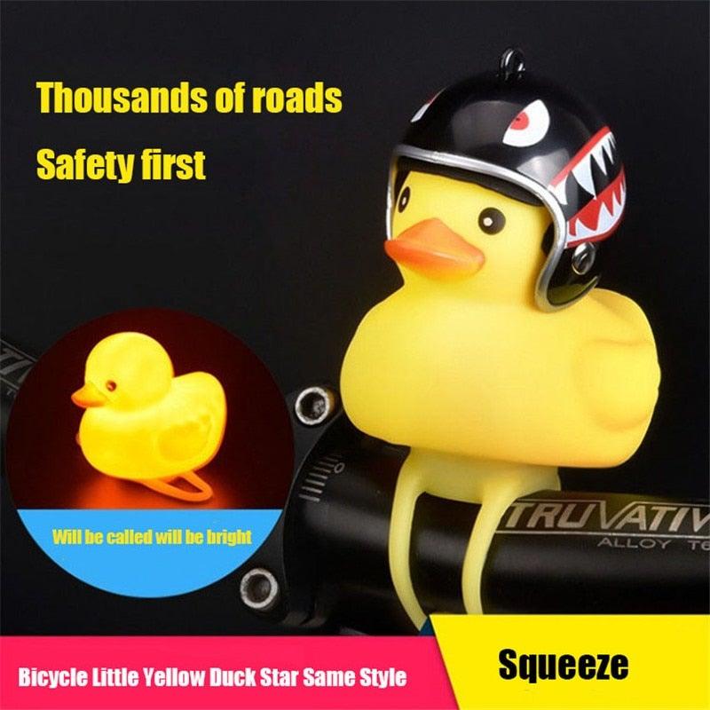 Yellow rubber bike duck wearing a helmet with a propeller and eyeglasses mounted on a bicycle handlebar.