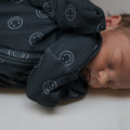 One-piece ribbed bamboo baby pajamas in charcoal grey and white with smiley print