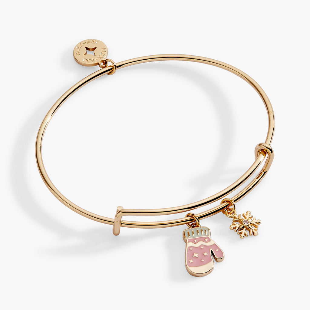 Gold charm bangle featuring a white enamel snowflake and crystal-embellished mitten charms.