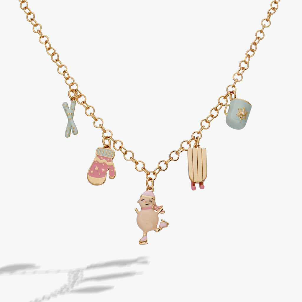 Winter Wonderland gold charm necklace with pastel pink and blue enamel charms including snowwoman, sled, and hot cocoa.