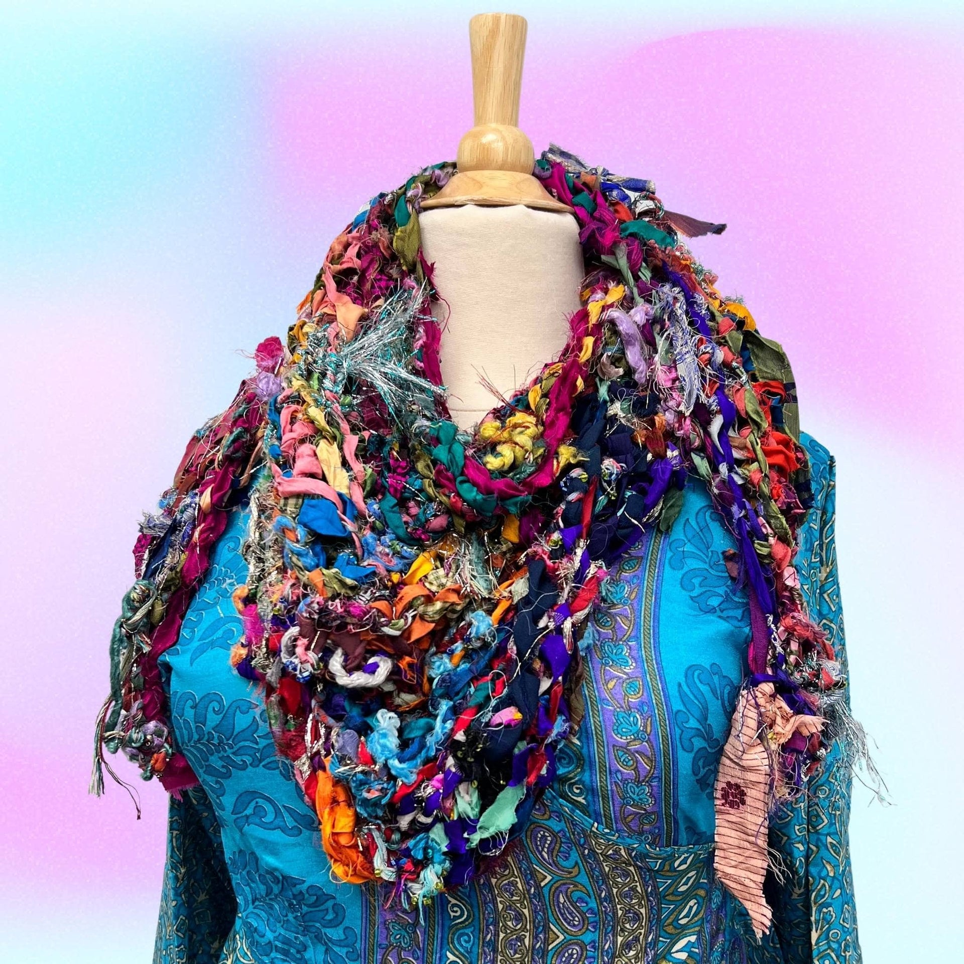 Vibrant bohemian shawl featuring multi-colored yarn in fuchsia, teal, mustard, and purple.