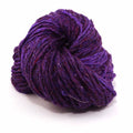 Skein of teal and navy Sand + Sea Tweed recycled silk yarn showing textured Sari silk speckles.