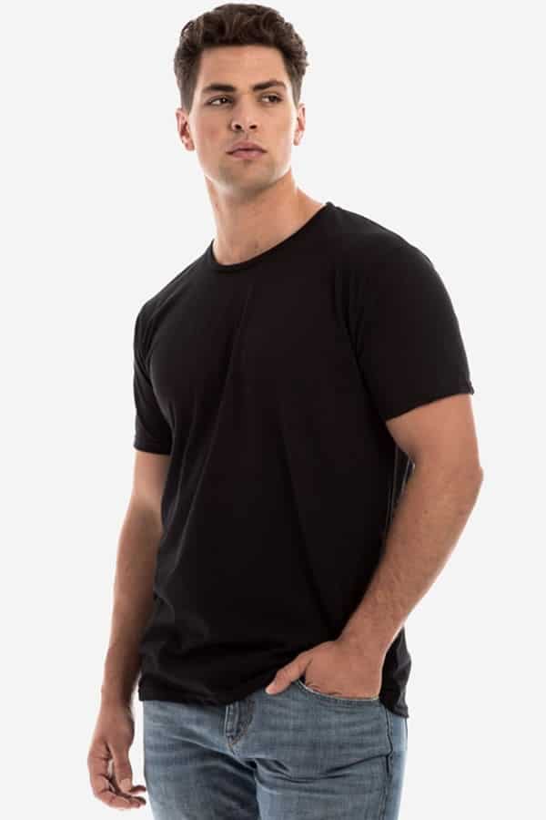 A man wearing a black slim-fit Karma crewneck t-shirt with a narrow neck rib.