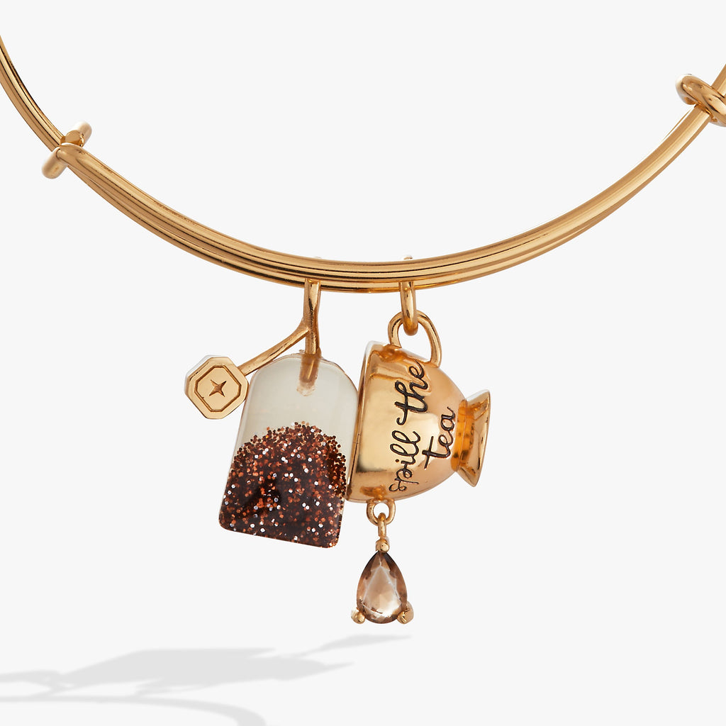 Spill the Tea charm bangle featuring a moving glitter tea bag and a teacup charm in gold, silver, and bronze tones.