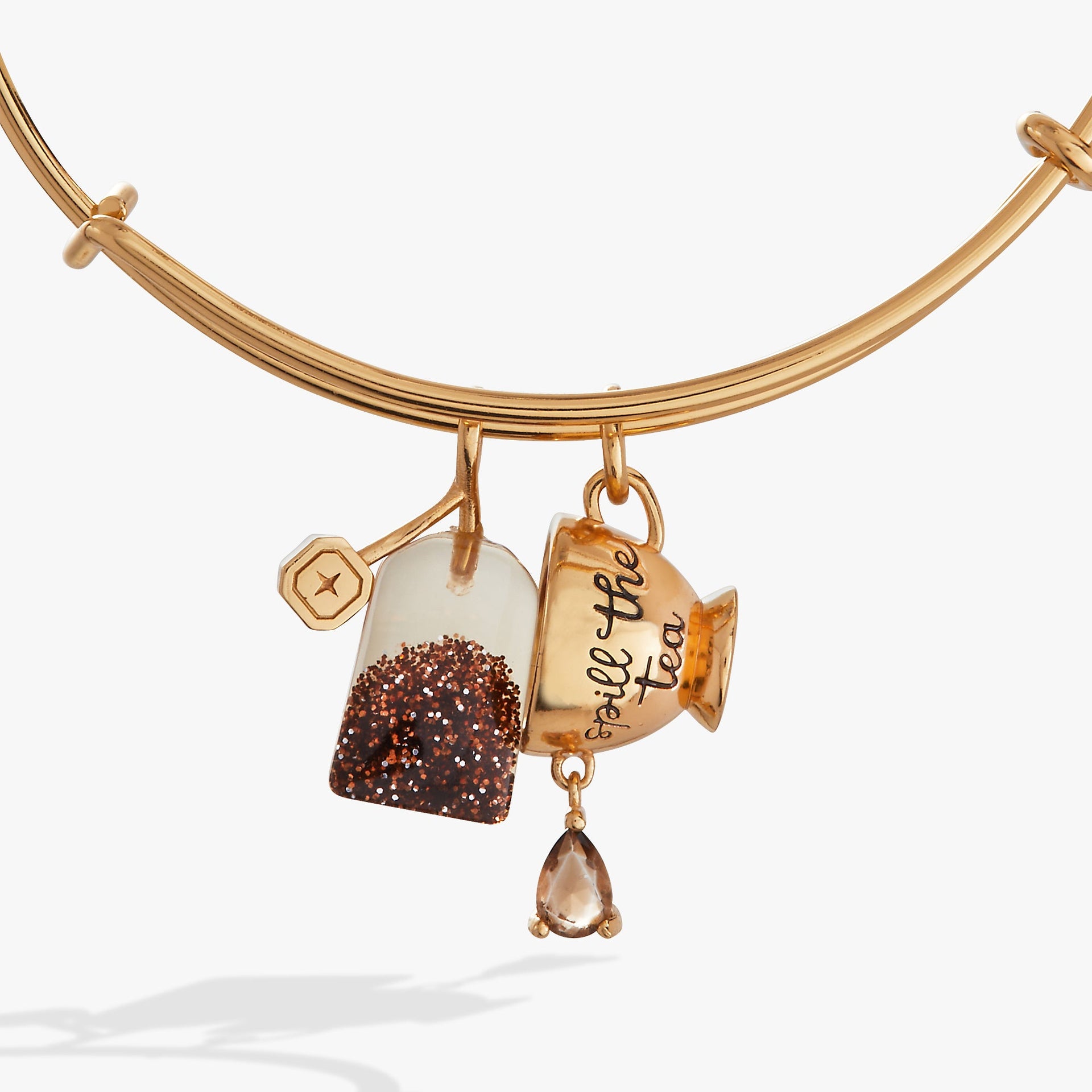 Spill the Tea charm bangle featuring a moving glitter tea bag and a teacup charm in gold, silver, and bronze tones.