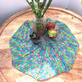 Multicolor spiral fan doily crochet project in blue, green, and pink silk yarn