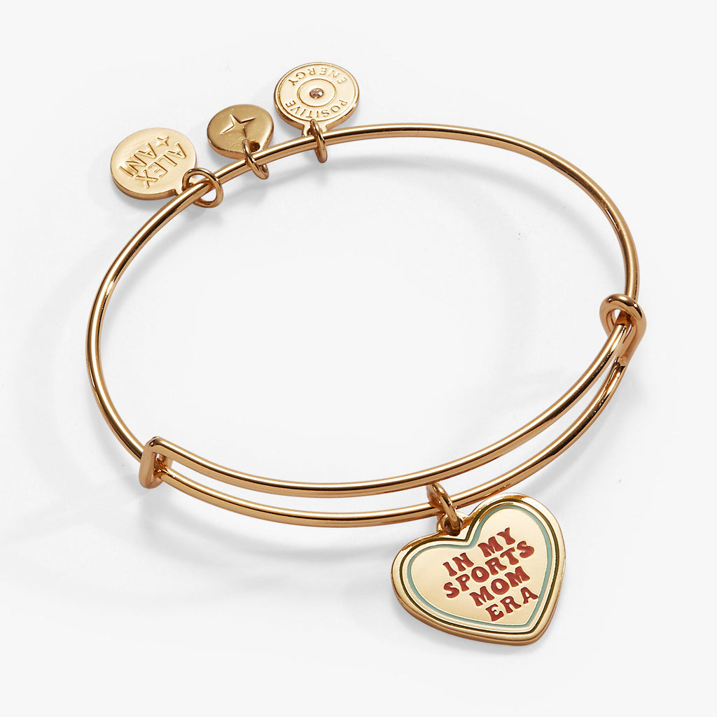 Expandable wire bangle with a heart charm reading In My Sports Mom Era in gold, white, red, and light-blue.
