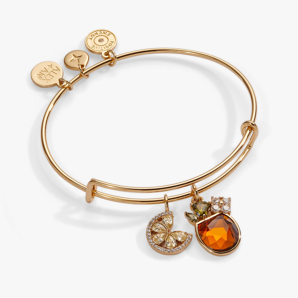 Gold-tone bangle featuring an Aperol Spritz charm with yellow and green crystal accents