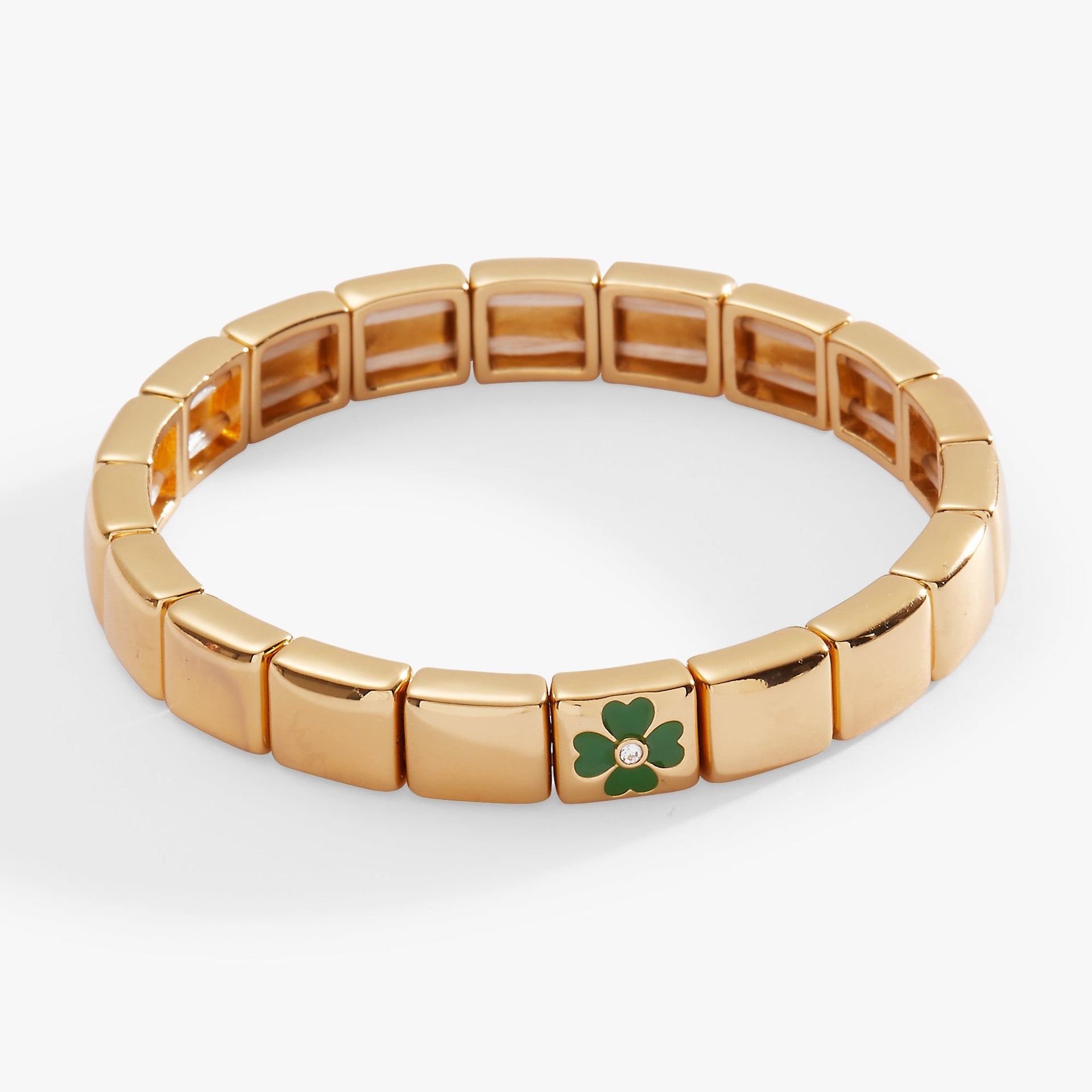 Gold-tone stretch bracelet with tiled beads and a crystal-encrusted four-leaf clover charm.
