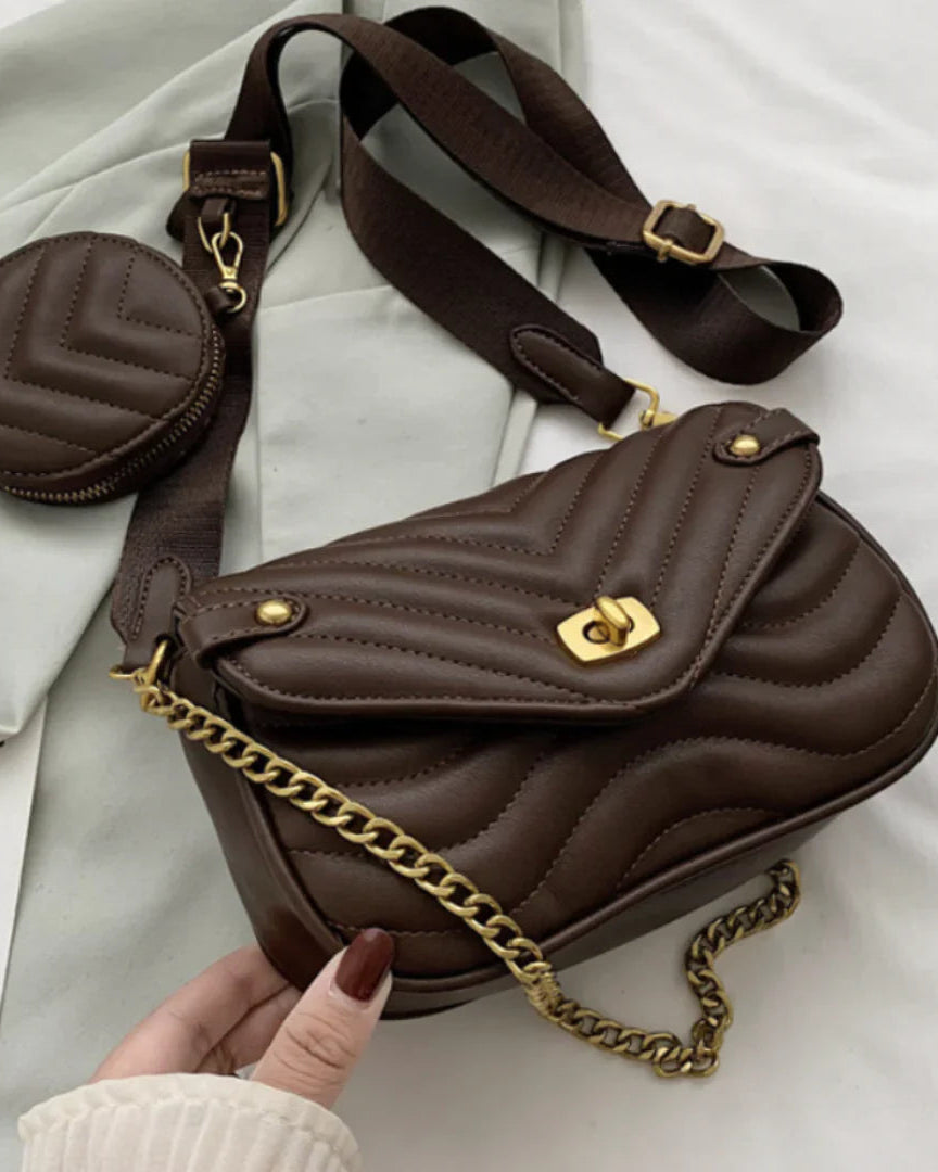 Brown quilted handbag with gold chain and matching coin purse on a light gray background.