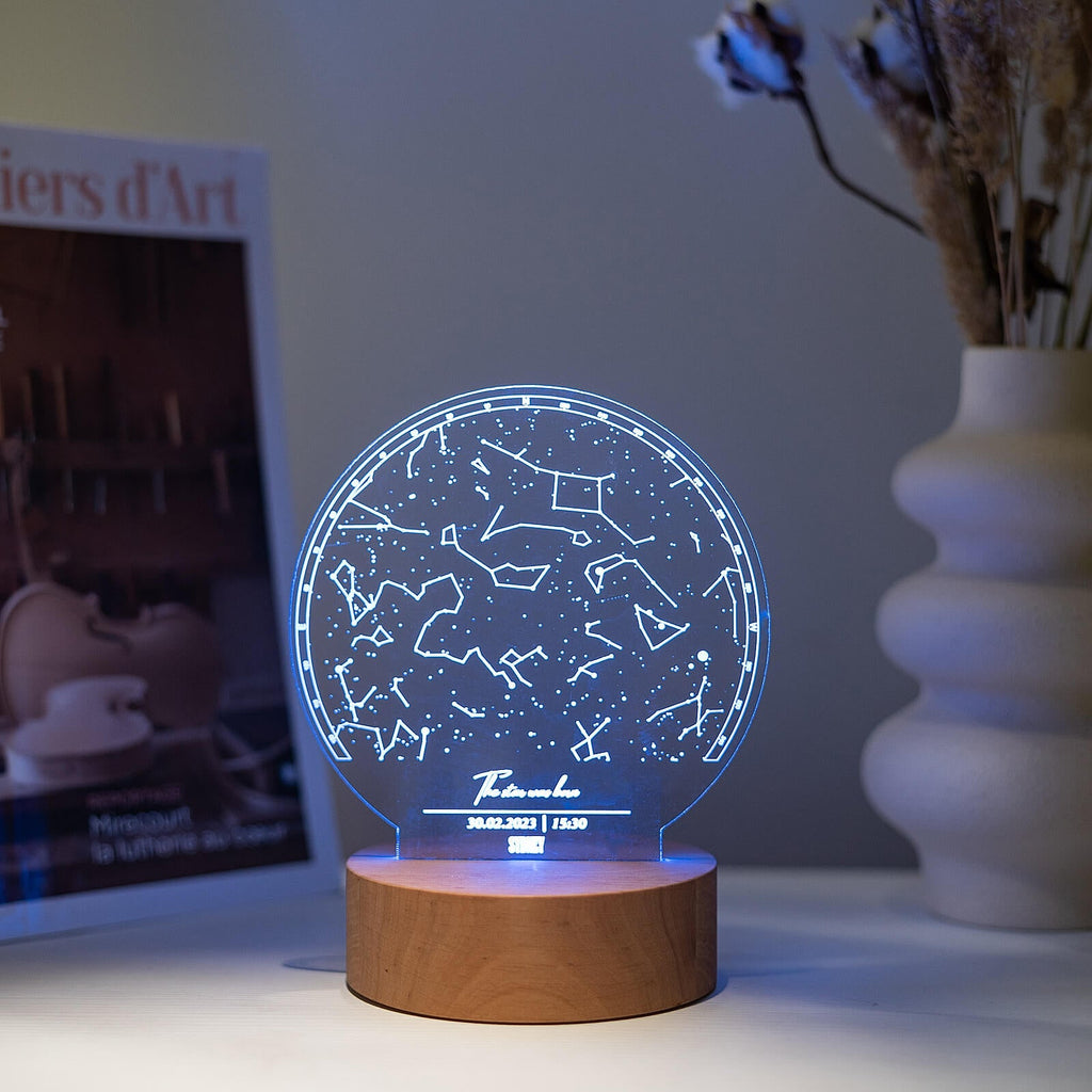 Custom star map night light with transparent acrylic and a natural wood base on a minimalist living room shelf.