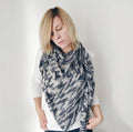 Grey and white lace weight crochet shawl featuring intricate star stitch pattern