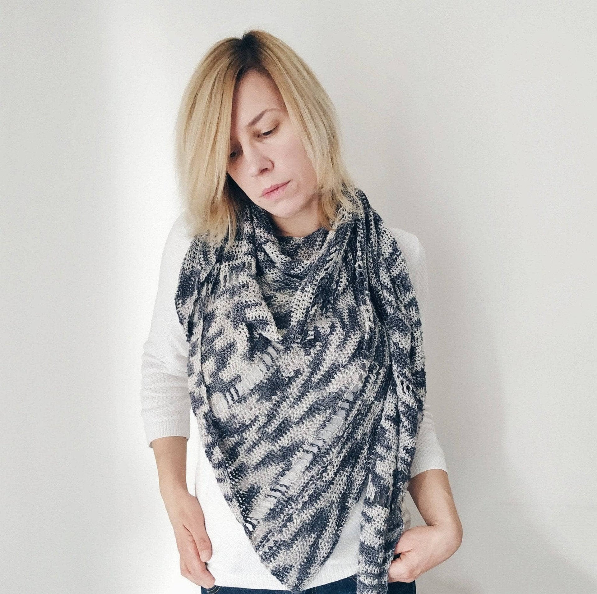 Grey and white lace weight crochet shawl featuring intricate star stitch pattern