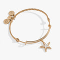 Gold-plated textured wire bangle featuring a two-tone silver and gold starfish charm with pavé crystal accents