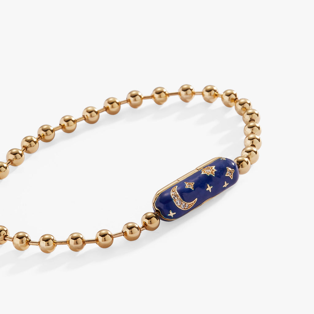Celestial-themed bracelet with gold moon and stars on a navy-blue enamel background.