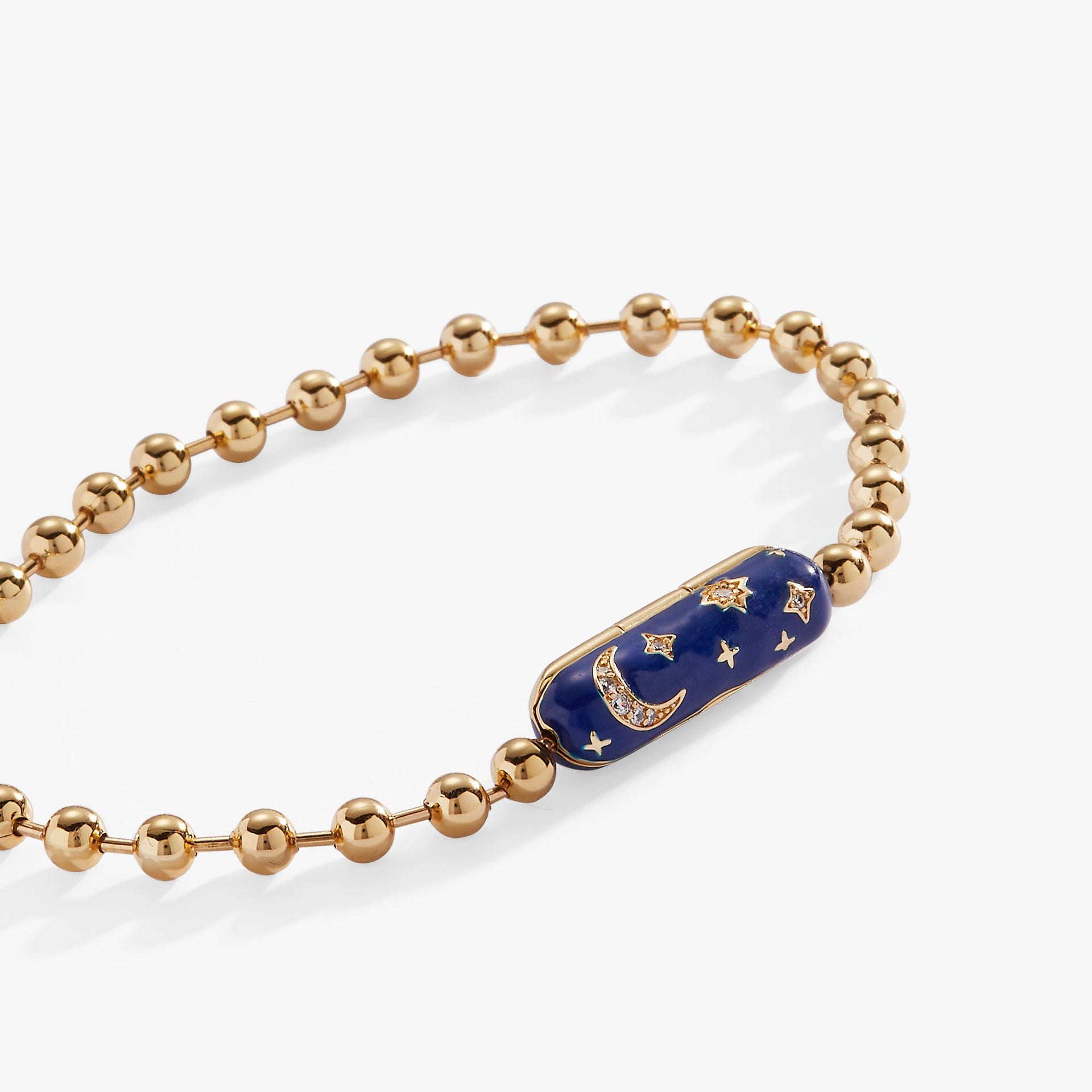 Celestial-themed bracelet with gold moon and stars on a navy-blue enamel background.