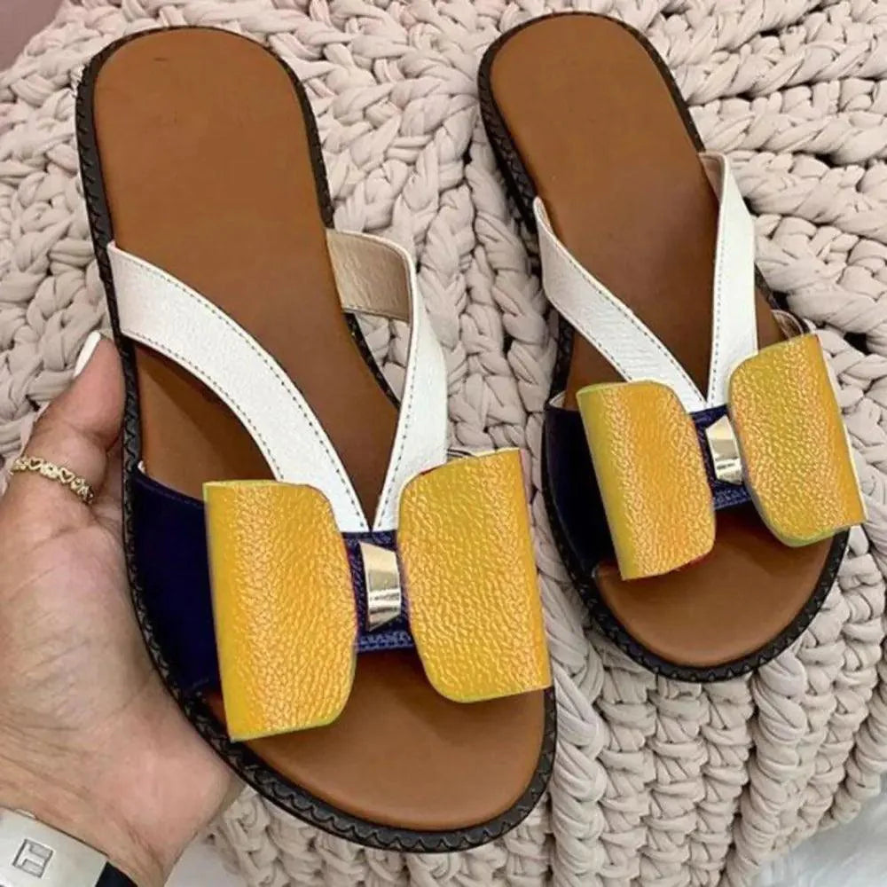 A pair of premium leather butterfly flat sandals available in white, blue, yellow, and gold.