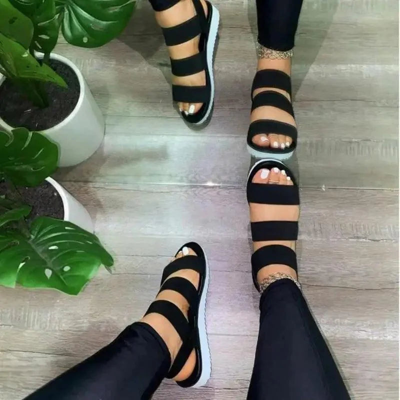 Women wearing colorful elastic beach sandals with white platform soles in a casual summer setting