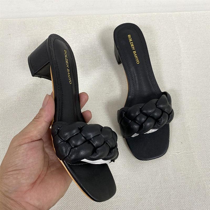 A pair of fuchsia women's woven square heel sandals with an open-toe slip-on design.