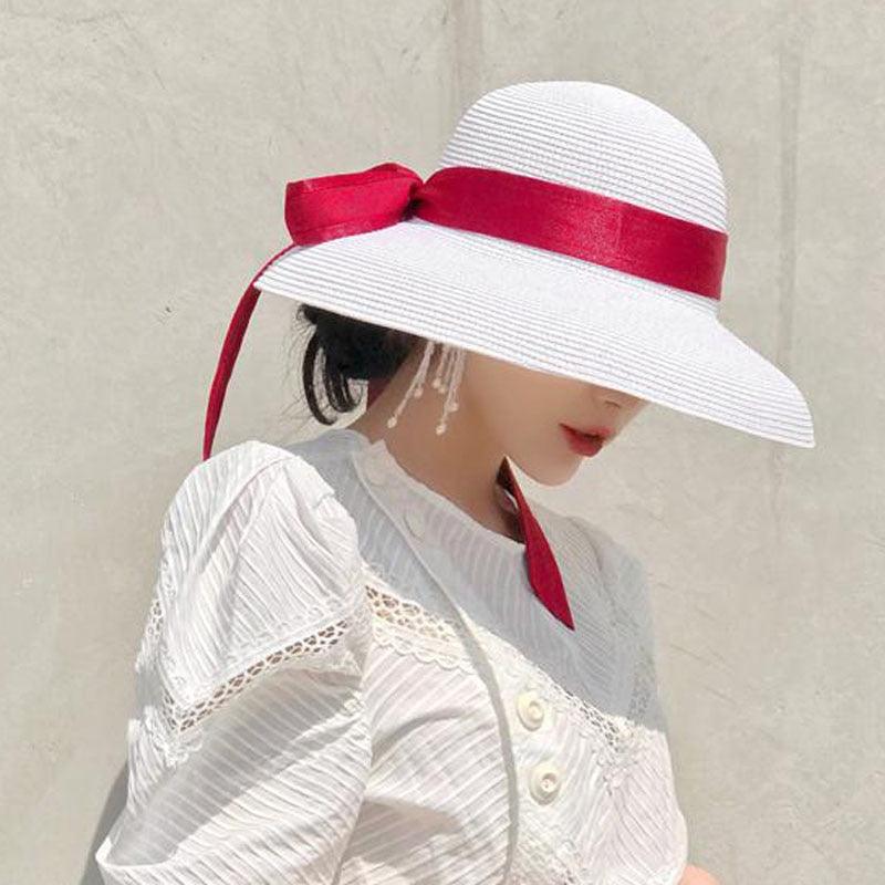 Woman wearing a vintage-style wide brim solid color sun hat at the beach