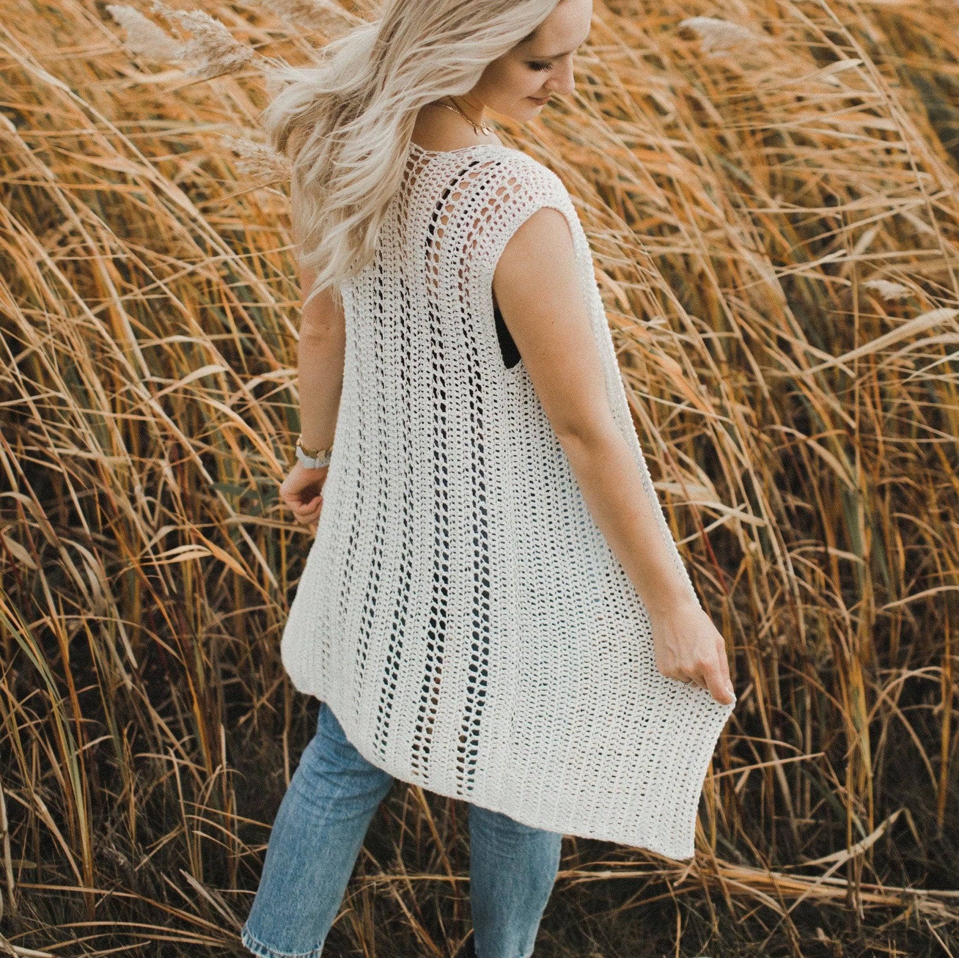 Model wearing a long off-white crochet V-neck vest in a relaxed bohemian style